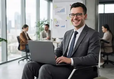 A businessman in a wheelchair using a laptop in a modern office